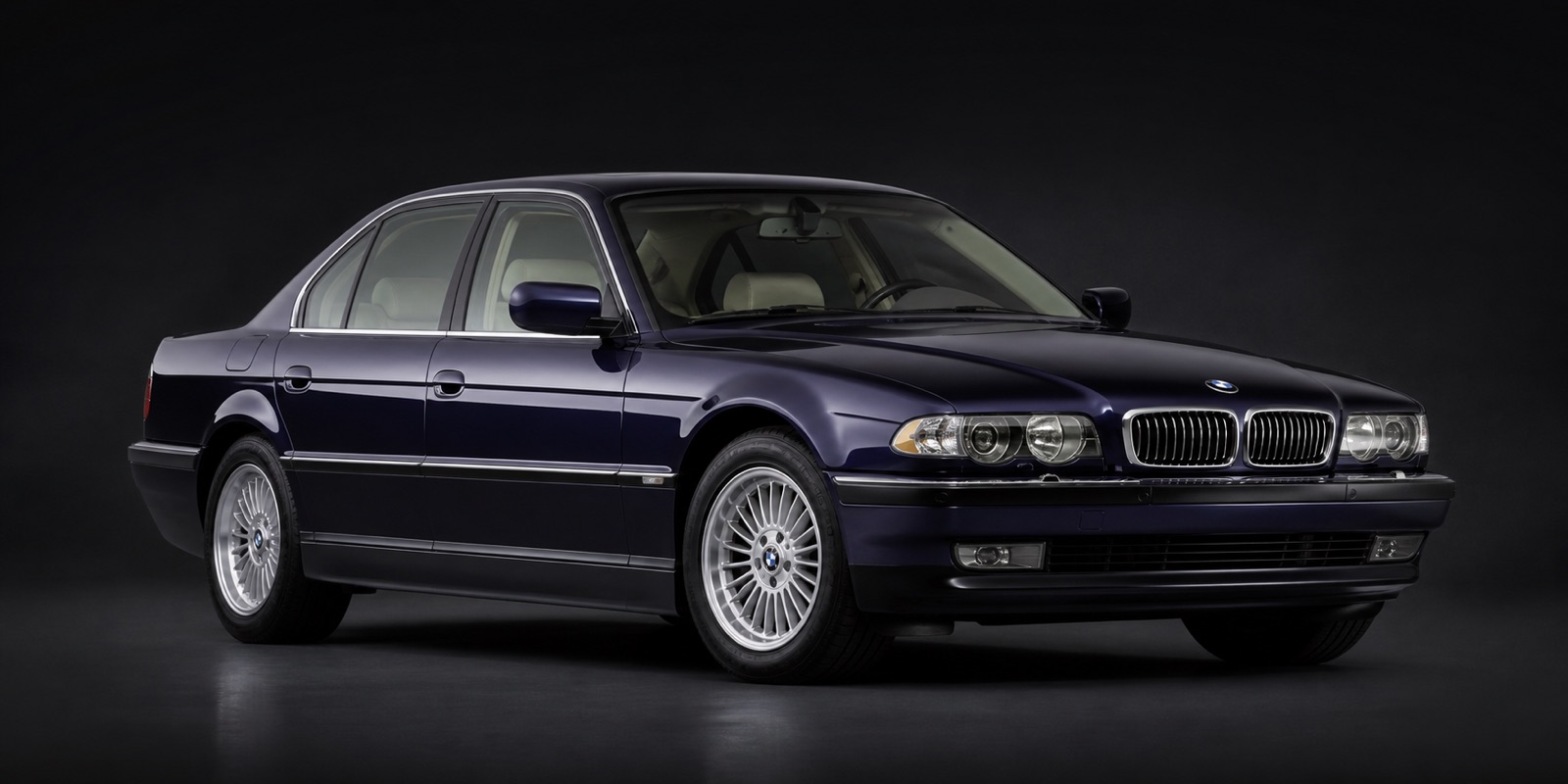 Dark Blue / Purple-Blue metallic BMW 740i in a dark photographic studio