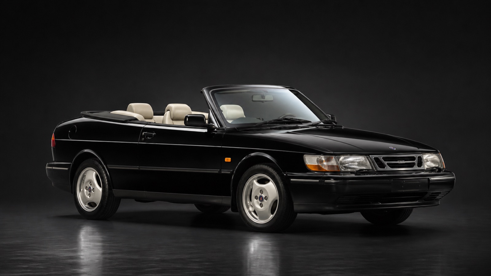 Black (cream interior) Saab 900/9-3 Convertible in a dark photographic studio